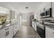 Bright kitchen features white cabinets, stainless appliances, and granite countertops at 338 Henry Butts Dr, Daytona Beach, FL 32114