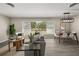Open-concept living room featuring a dining area, hardwood floors, a large window, and modern furnishings at 338 Henry Butts Dr, Daytona Beach, FL 32114