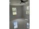Bright bedroom features tile floors, a ceiling fan, and natural light from large windows at 3431 Orchid Dr, Indian Lake Estates, FL 33855