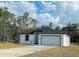 Charming single Gathering home showcasing a well-manicured lawn and an attached two-car garage at 3431 Orchid Dr, Indian Lake Estates, FL 33855