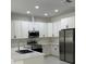 Modern kitchen features white cabinets, stainless steel appliances, and sleek countertops at 3431 Orchid Dr, Indian Lake Estates, FL 33855