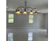 Spacious living room with elegant chandelier and natural light from large windows at 3431 Orchid Dr, Indian Lake Estates, FL 33855