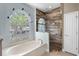 Bathroom featuring an arched window, a garden tub, and a glass-enclosed shower at 3711 Half Moon Dr, Orlando, FL 32812