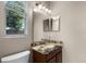 Powder room featuring granite countertops, decorative mirror and a large window at 3711 Half Moon Dr, Orlando, FL 32812
