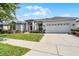 Inviting single-story home with a well-manicured lawn, a two-car garage, and a charming red front door at 3711 Half Moon Dr, Orlando, FL 32812