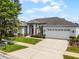 Single-story home featuring a pristine lawn, a spacious driveway, and a vibrant red front door at 3711 Half Moon Dr, Orlando, FL 32812