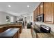 Kitchen with stainless steel appliances, wood cabinets, and granite countertops. Leading to living room at 3711 Half Moon Dr, Orlando, FL 32812