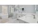 Modern bathroom with double sink vanity, soaking tub, and glass-enclosed shower at 3816 Eagle Isle Cir, Kissimmee, FL 34746