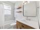 Bright bathroom featuring wood shelves, a modern vanity, and a tub with white subway tile at 3816 Eagle Isle Cir, Kissimmee, FL 34746
