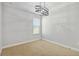 Bedroom with modern light fixture and large window bringing in natural light to the neutral carpet at 3906 Carrick Bend Dr, Kissimmee, FL 34746