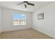 Sunlit bedroom featuring a large window, neutral carpet, and a view of the landscape at 3906 Carrick Bend Dr, Kissimmee, FL 34746