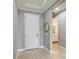 Bright foyer with tile flooring, decorative mirror, white trim, and view into the bathroom at 3906 Carrick Bend Dr, Kissimmee, FL 34746