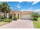 Inviting single-story home with tile roof, brick driveway, manicured lawn, and lush tropical landscaping at 3906 Carrick Bend Dr, Kissimmee, FL 34746