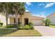 Charming single-story home with a tile roof, lush landscaping, and a brick driveway on a sunny day at 3906 Carrick Bend Dr, Kissimmee, FL 34746