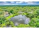 Aerial view of a home showcasing a large pond and mature trees at 400 Timbercove Pl, Longwood, FL 32779