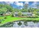 View of backyard with a lake, manicured landscaping and a pool at 400 Timbercove Pl, Longwood, FL 32779