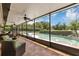 Relaxing screened-in patio featuring comfortable seating, ceiling fans, and a view of the sparkling pool and lush backyard at 400 Timbercove Pl, Longwood, FL 32779
