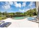Inviting pool area with poolside lounge chairs, mature landscaping, and picturesque lake views at 400 Timbercove Pl, Longwood, FL 32779