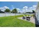 A cozy backyard features a paved patio with outdoor seating, lush green grass, and a pristine white fence at 417 Monticello Dr, Altamonte Springs, FL 32701