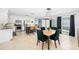 Dining area with view of kitchen; features a stylish chandelier, a dining table with green chairs and stainless appliances at 417 Monticello Dr, Altamonte Springs, FL 32701