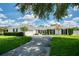 Charming home exterior with a well-manicured lawn, mature trees, and a spacious driveway leading to the garage at 417 Monticello Dr, Altamonte Springs, FL 32701