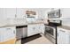 Updated kitchen featuring stainless steel appliances, granite countertops, and white cabinetry, with stainless dishwasher at 417 Monticello Dr, Altamonte Springs, FL 32701