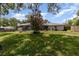 A spacious backyard featuring a screened pool, mature trees, and a well-maintained lawn at 419 W Orange St, Altamonte Springs, FL 32714