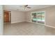 View of the tiled living room with access to the pool area through sliding glass doors at 419 W Orange St, Altamonte Springs, FL 32714