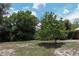 Large backyard with grass, trees, and a blue sky at 438 Romano Ave, Orlando, FL 32807