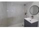 Sleek bathroom featuring a new vanity and walk-in shower adorned with marble-style tile at 438 Romano Ave, Orlando, FL 32807