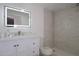 Updated bathroom with a lighted mirror, vanity with storage, and a walk-in shower with marble-style tile at 438 Romano Ave, Orlando, FL 32807