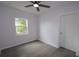 Bright bedroom featuring a ceiling fan, window, white walls and modern wood-look floors at 438 Romano Ave, Orlando, FL 32807