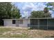 Exterior of home with enclosed lanai, trees, grass, and a blue sky at 438 Romano Ave, Orlando, FL 32807