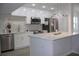 Modern kitchen features stainless steel appliances, white cabinetry, and an island with quartz countertops at 438 Romano Ave, Orlando, FL 32807