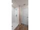 Modern bathroom featuring a shower with white tile surround, wood-look flooring, and crisp white door at 5641 Brosnan Rd, St Cloud, FL 34771