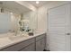 Modern bathroom with double sinks, a large mirror, neutral countertops, and contemporary fixtures and finishes at 5641 Brosnan Rd, St Cloud, FL 34771