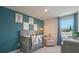 Charming Bedroom with a gray crib, soothing blue wall, and plenty of room for a growing Gathering at 5641 Brosnan Rd, St Cloud, FL 34771