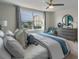Bright bedroom with a ceiling fan, large window, stylish decor, and a comfortable bed with blue accents at 5641 Brosnan Rd, St Cloud, FL 34771