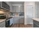 Modern kitchen with gray cabinets, stainless steel appliances, and stylish backsplash at 5641 Brosnan Rd, St Cloud, FL 34771