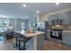 Modern kitchen island with bar stool seating, stainless steel appliances, and open-concept layout at 5641 Brosnan Rd, St Cloud, FL 34771