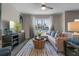 Inviting living room with a large window, stylish decor, a comfortable sofa, and a modern ceiling fan at 5641 Brosnan Rd, St Cloud, FL 34771