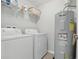 Neat laundry room with washer, dryer, water heater, and shelving for storage at 600 Northern Way # 607, Winter Springs, FL 32708