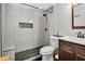 Modern bathroom featuring gray tile walls, a walk-in shower, and a dark wood vanity at 706 19Th St, Orlando, FL 32805