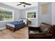 Cozy bedroom with light blue walls, wood-look floors, and a comfortable chair by the window at 706 19Th St, Orlando, FL 32805