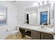 Bright bathroom featuring a large mirror, white cabinets, and a neutral color scheme, offering a serene space at 814 Calabria Ave, Davenport, FL 33897