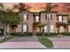 Charming townhome showcasing a brick driveway, tropical landscaping, and two-story facade at 814 Calabria Ave, Davenport, FL 33897