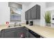 This kitchen features gray cabinets, neutral countertops, and a stainless steel sink under the window at 814 Calabria Ave, Davenport, FL 33897