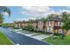 Charming townhomes with well-manicured lawns and palm trees line a quiet street, showcasing curb appeal at 814 Calabria Ave, Davenport, FL 33897