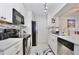Galley kitchen features stainless steel appliances, white cabinets, and tile backsplash at 8709 Knightsbridge Ct # B, Kissimmee, FL 34747