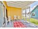 Covered patio with chairs, table, red and grey rug and view to the community swimming pool at 8709 Knightsbridge Ct # B, Kissimmee, FL 34747